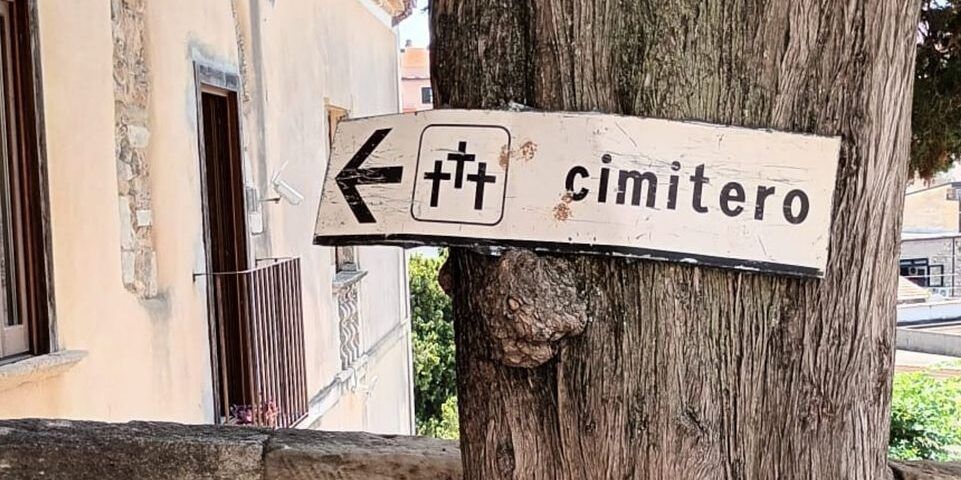 Il cartello stradale che indica il cimitero davanti al comune di San Lucido. Il sindaco: «Grande amarezza»