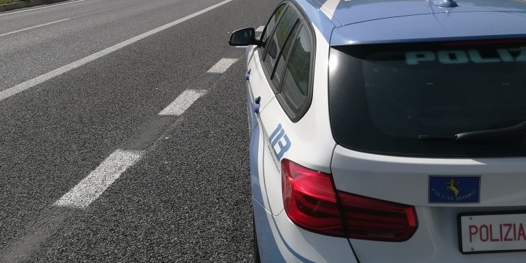 Auto della Polizia Stradale sulla carreggiata nella fotografia della fonte